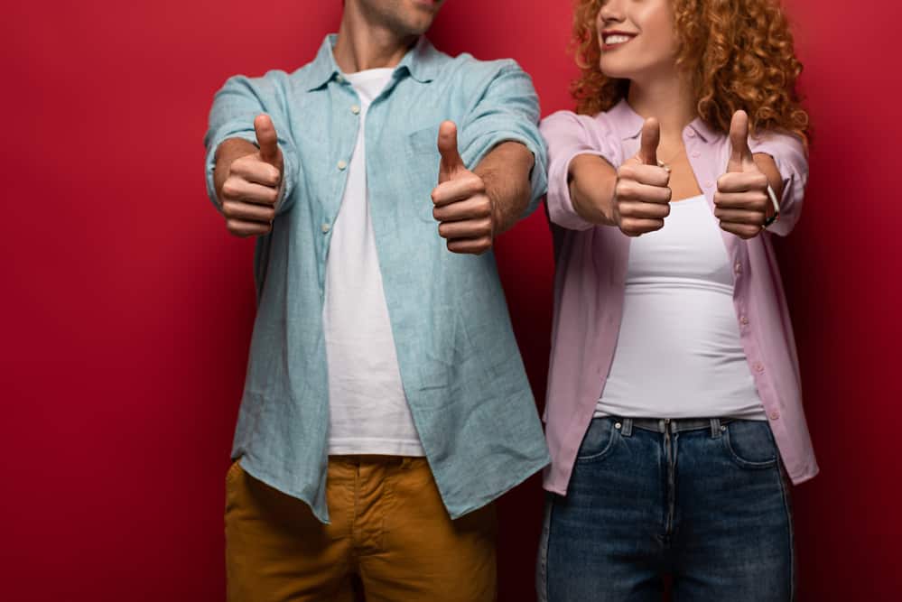 couple giving thumbs up and smiling