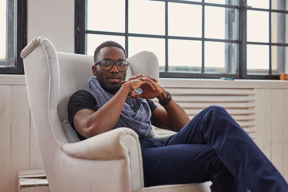 A black man relaxing in a white chair