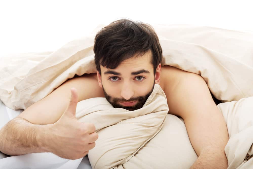 man on bed giving thumbs up