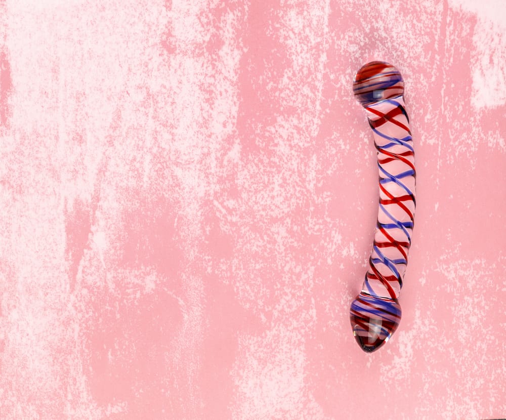glass dildo on pink background