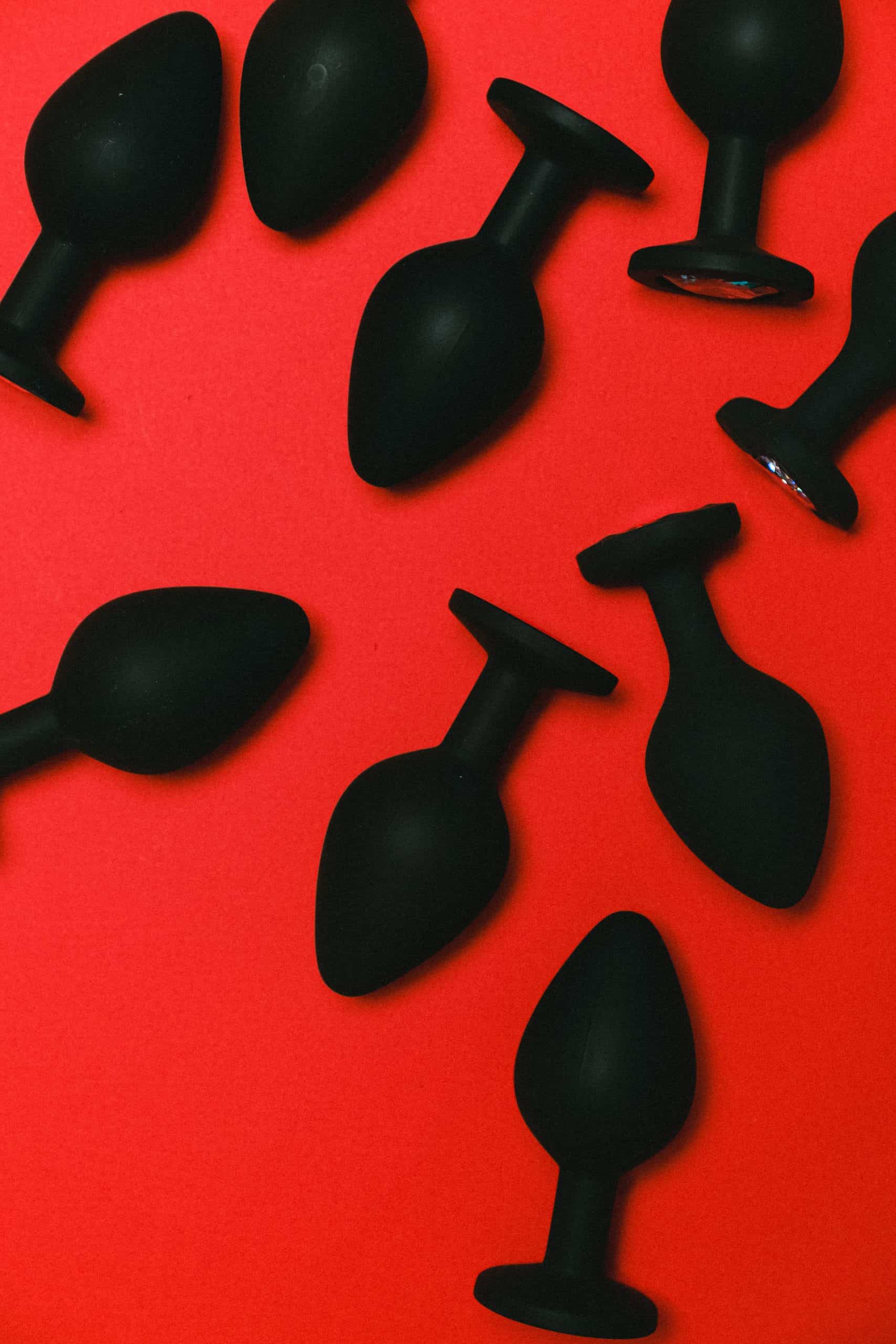 Black Anal Sex Toys in A Red Background