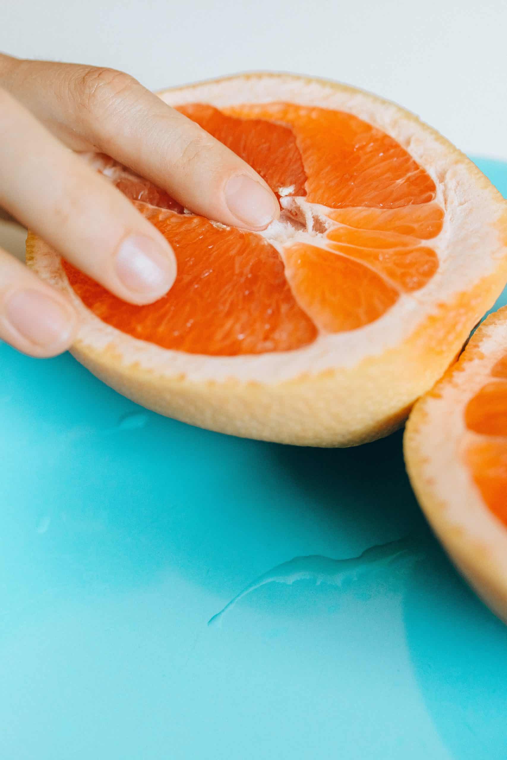 Finger in orange fruit as genital concept