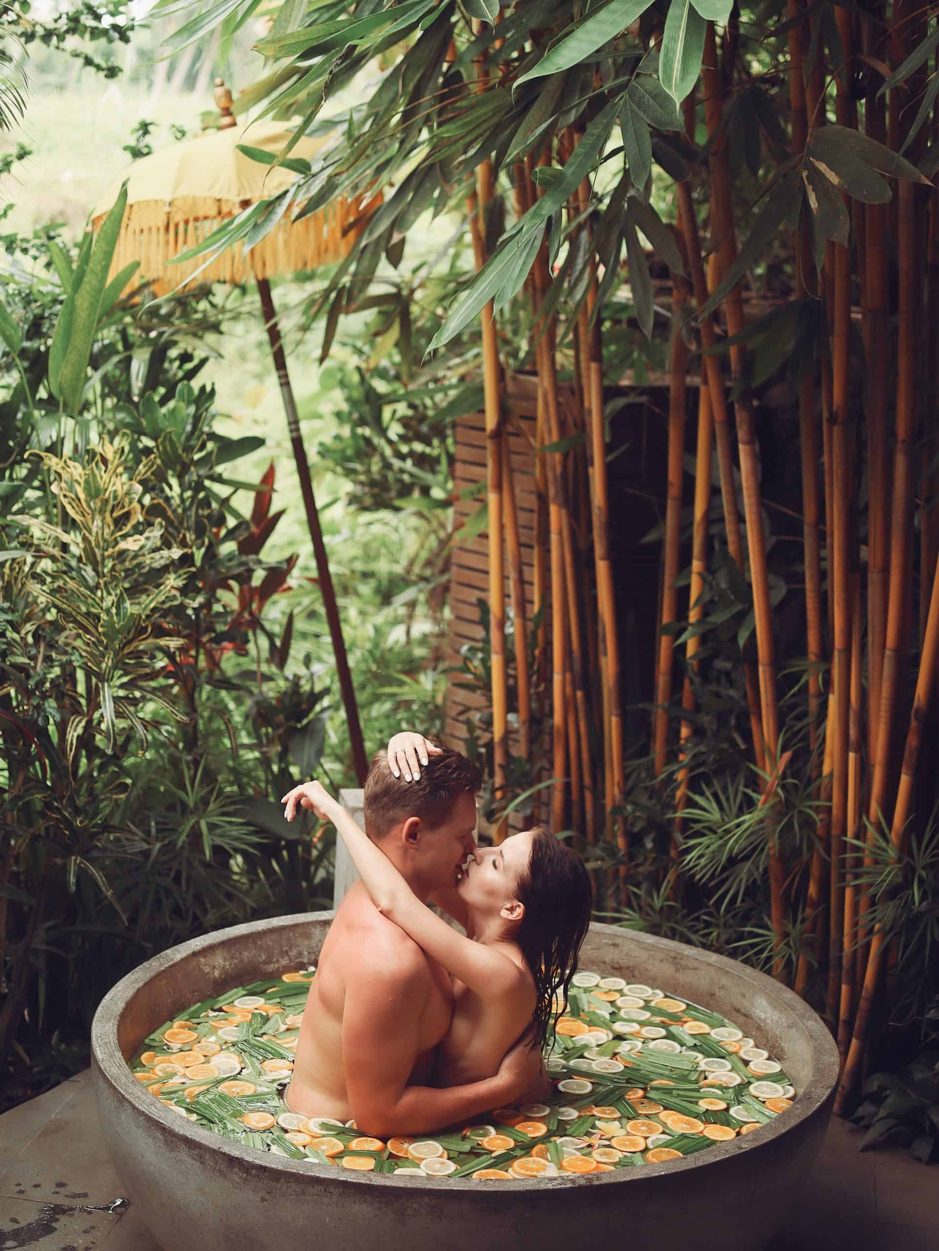 Sensual couple hugging and kissing in stone fruit bath