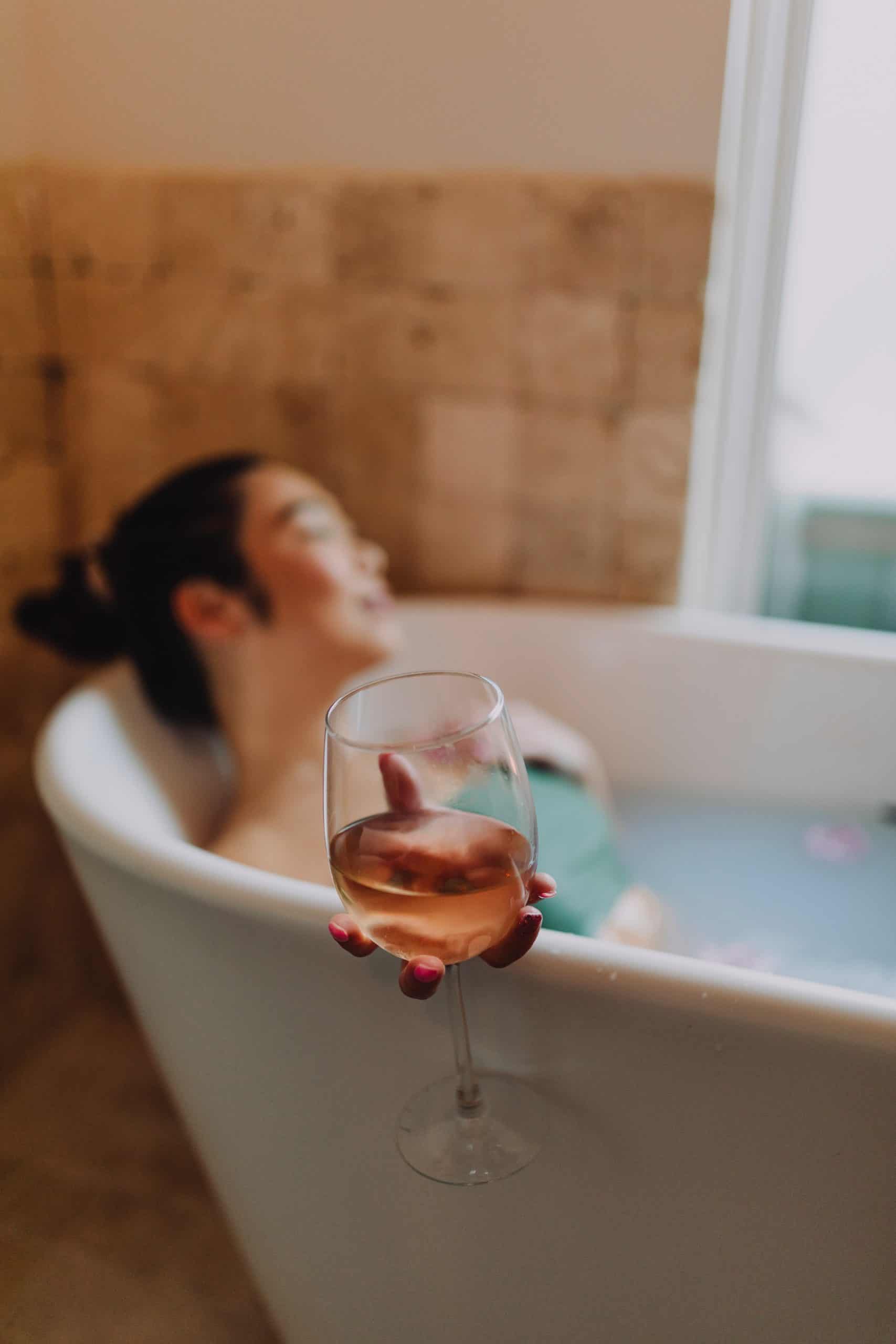 Woman in White Bathtub Holding Clear Drinking Glass of Wine